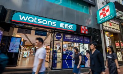 Pedestrians walk past a Watsons store