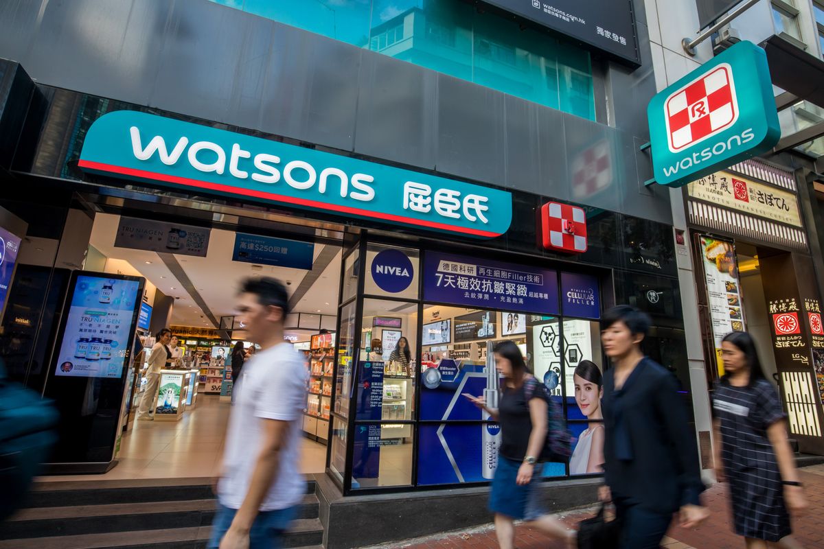 Pedestrians walk past a Watsons store