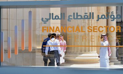 Saudi participants pass by a sign of the Financial Sector Conference held in Riyadh, on April 24, 2019.